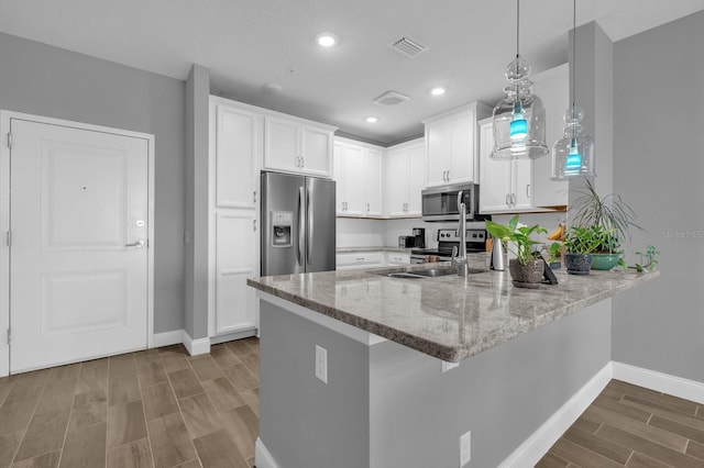 7573 Laureate Blvd Unit 1-404, Orlando, FL 32827 - kitchen with appliances with stainless steel finishes, baseboards, a peninsula, wood tiled floors, and recessed lighting