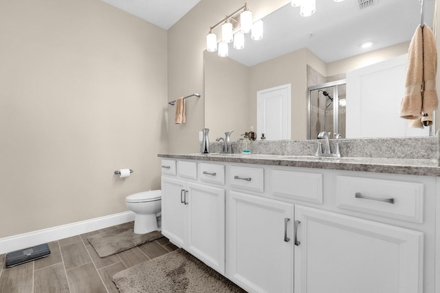 7573 Laureate Blvd Unit 1-404, Orlando, FL 32827 - bathroom featuring double vanity, a shower stall, baseboards, toilet, and wood tiled floors