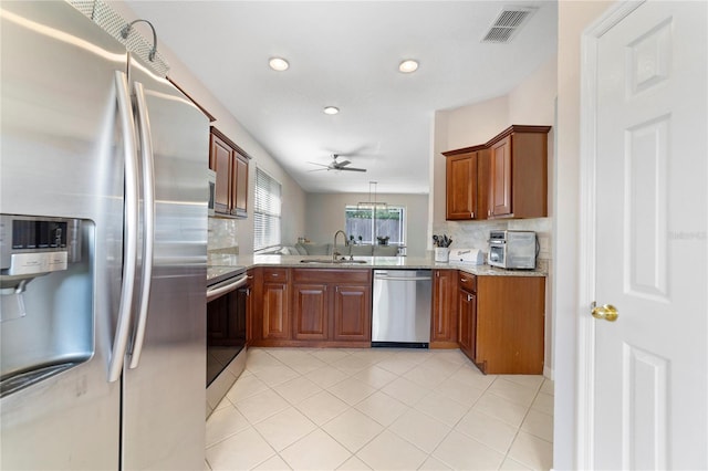 4558 Redmond Pl, Sanford, FL 32771 - kitchen with appliances with stainless steel finishes, tasteful backsplash, ceiling fan, brown cabinets, and a sink