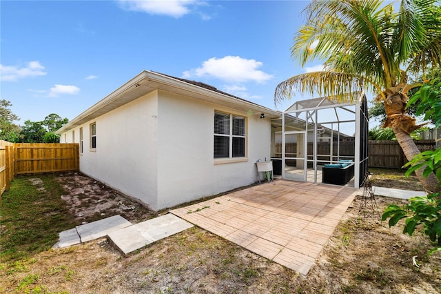 4558 Redmond Pl, Sanford, FL 32771 - rear view of property with stucco siding, a fenced backyard, a patio area, glass enclosure, and a sink