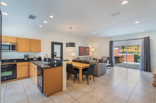 kitchen with black appliances, a sink, a peninsula, open floor plan, and recessed lighting