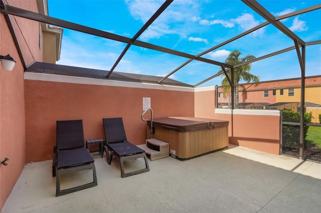 view of patio / terrace with a hot tub and a lanai