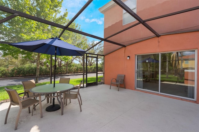 view of patio / terrace with outdoor dining space and a lanai