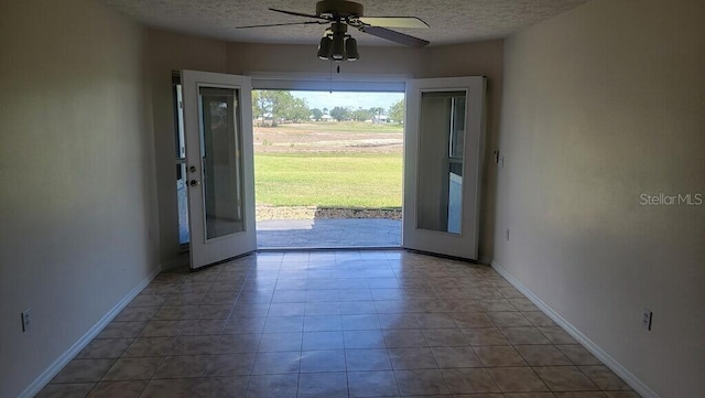 entrance foyer featuring a textured ceiling, ceiling fan, baseboards, and tile patterned floors