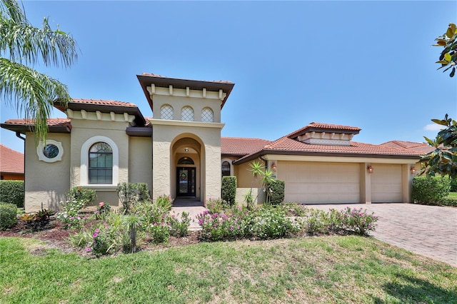 2921 Falconhill Dr, Apopka, FL 32712 - mediterranean / spanish-style home with an attached garage, a tiled roof, driveway, and stucco siding
