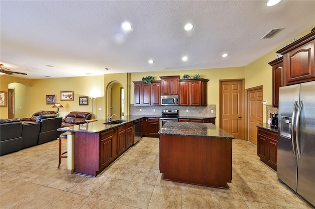 2921 Falconhill Dr, Apopka, FL 32712 - kitchen featuring appliances with stainless steel finishes, arched walkways, a sink, a peninsula, and open floor plan