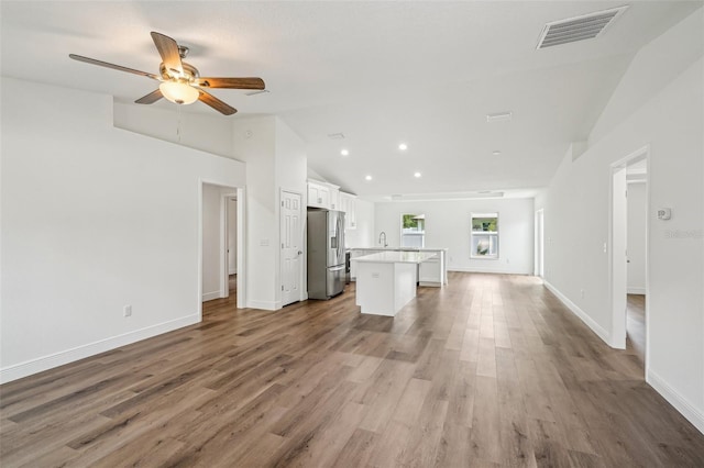 13881 SW 80th Ave, Ocala, FL 34473 - unfurnished living room featuring vaulted ceiling, ceiling fan, wood finished floors, baseboards, and a sink