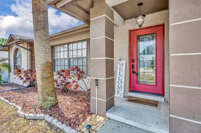 doorway to property featuring stucco siding