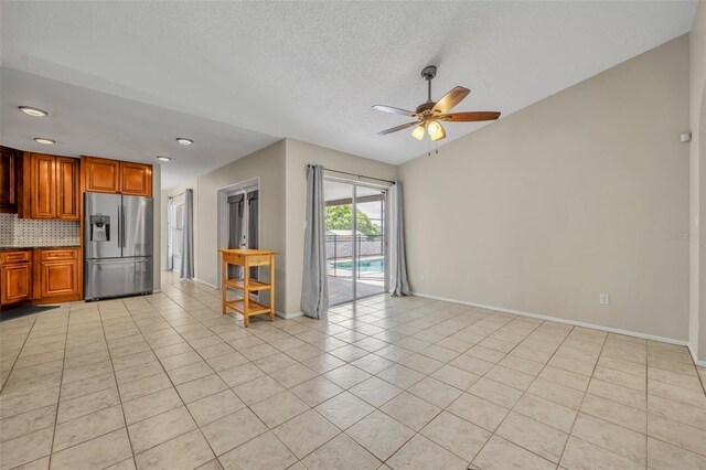unfurnished living room featuring a ceiling fan, light tile patterned floors, baseboards, a textured ceiling, and recessed lighting