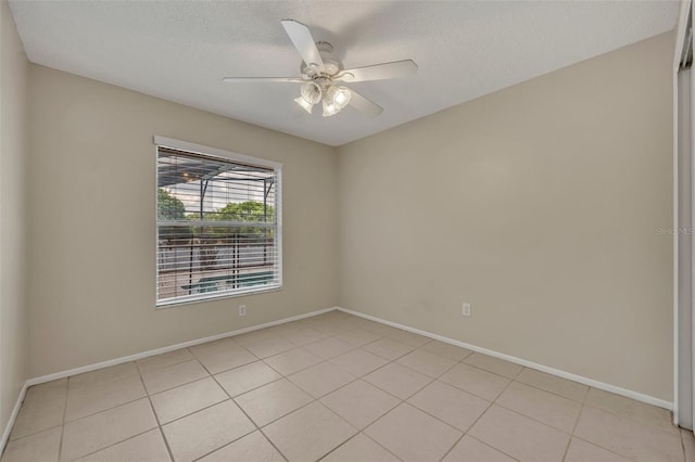 unfurnished room with light tile patterned floors, a textured ceiling, ceiling fan, and baseboards