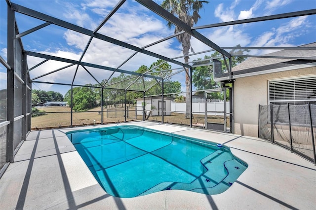 view of swimming pool with a patio area, a storage shed, an outbuilding, a lanai, and fence