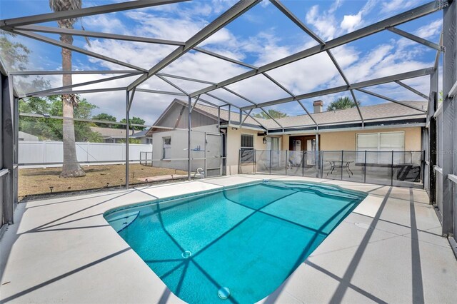 view of pool featuring a patio area, fence, and glass enclosure