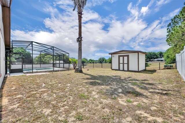 fenced backyard with a shed, a lanai, and an outdoor structure