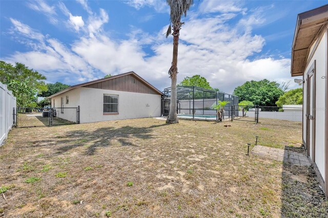 view of yard with a gate and a lanai
