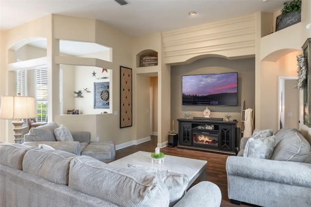 441 Hightower Dr, Debary, FL 32713 - living area with dark wood finished floors, baseboards, a glass covered fireplace, and arched walkways