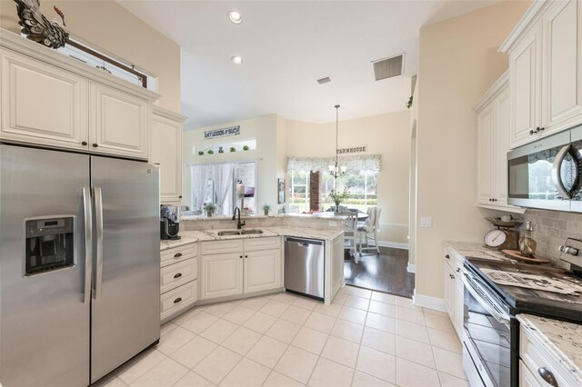 441 Hightower Dr, Debary, FL 32713 - kitchen with appliances with stainless steel finishes, a sink, backsplash, light tile patterned flooring, and a peninsula