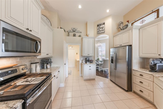 441 Hightower Dr, Debary, FL 32713 - kitchen featuring appliances with stainless steel finishes, decorative backsplash, light tile patterned flooring, light stone countertops, and recessed lighting