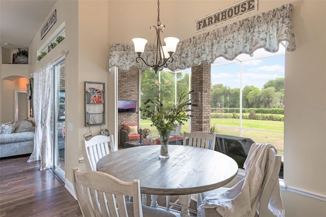 441 Hightower Dr, Debary, FL 32713 - dining space featuring a high ceiling, a chandelier, arched walkways, wood finished floors, and baseboards