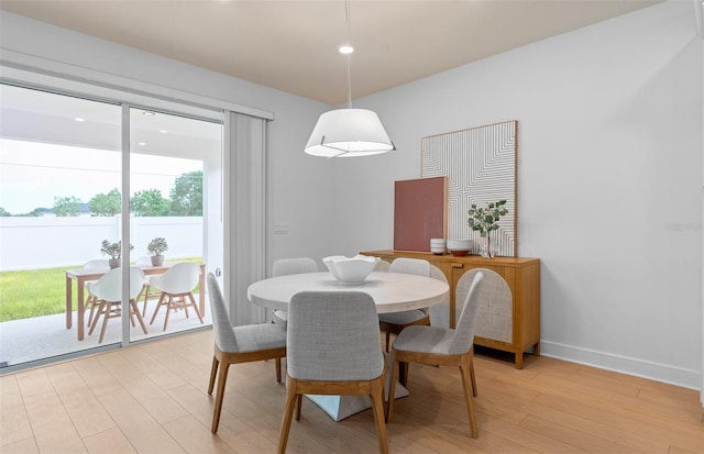 dining space featuring light wood finished floors and baseboards