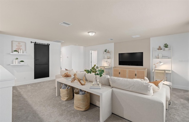 living room featuring light colored carpet, a barn door, and baseboards