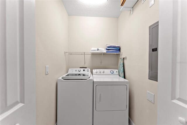 1596 Moon Valley Dr, Davenport, FL 33896 - clothes washing area with washer and dryer, a textured ceiling, and electric panel