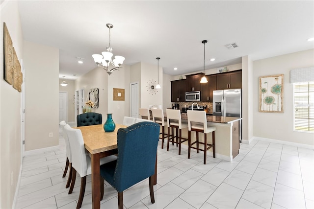 1596 Moon Valley Dr, Davenport, FL 33896 - dining area with a chandelier, light marble finish flooring, recessed lighting, and baseboards