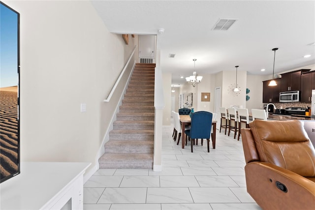 1596 Moon Valley Dr, Davenport, FL 33896 - stairs featuring a chandelier, recessed lighting, marble look tiles, and baseboards