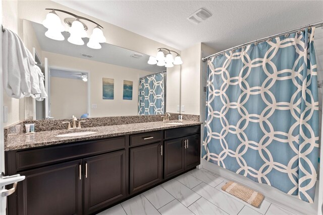 1596 Moon Valley Dr, Davenport, FL 33896 - full bathroom with double vanity, marble look tiles, a textured ceiling, and a shower with shower curtain