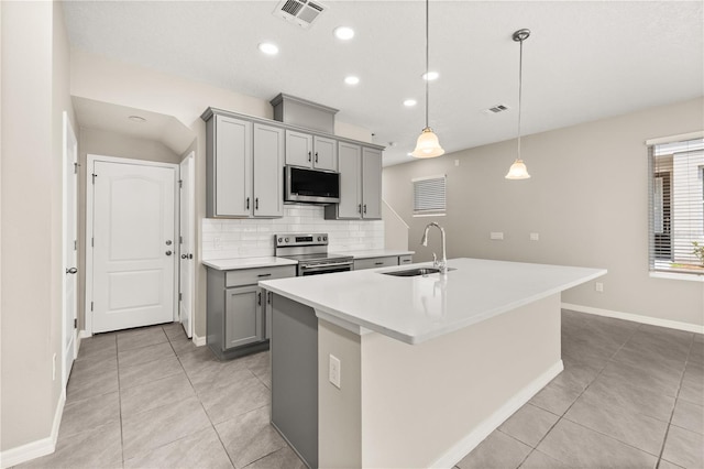 1915 Terrapin Rd, Ocoee, FL 34761 - kitchen featuring gray cabinets, a sink, appliances with stainless steel finishes, light tile patterned flooring, and an island with sink