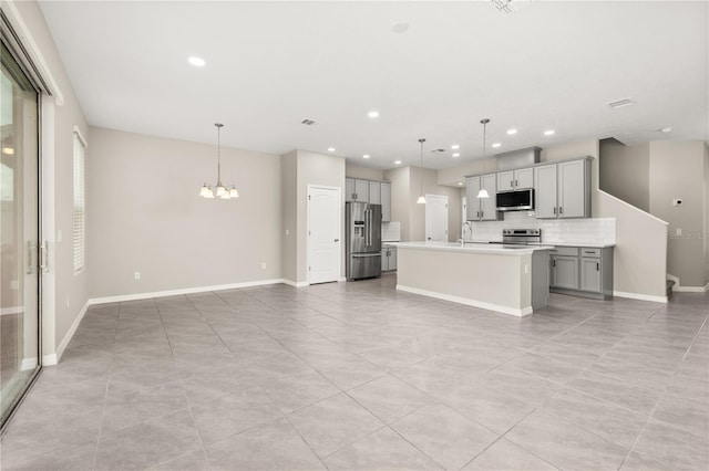 1915 Terrapin Rd, Ocoee, FL 34761 - kitchen featuring appliances with stainless steel finishes, gray cabinetry, a chandelier, tasteful backsplash, and light tile patterned floors