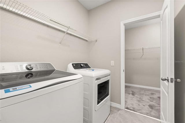 1915 Terrapin Rd, Ocoee, FL 34761 - laundry area featuring washing machine and dryer, baseboards, light tile patterned floors, and light colored carpet