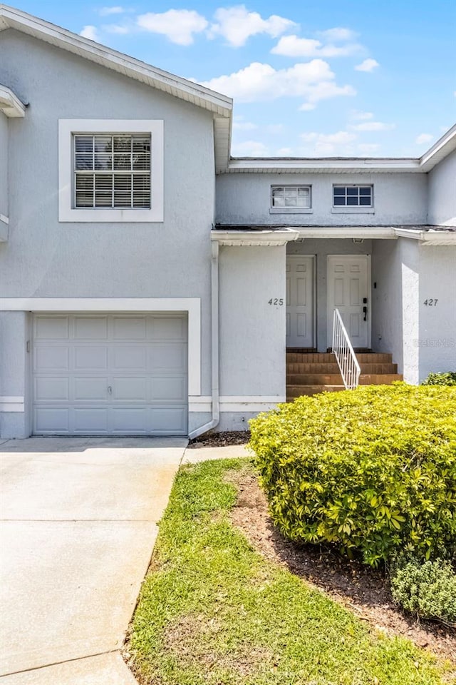 425 Eagle Ridge Dr Unit 425, Davenport, FL 33837 - view of front of property with an attached garage, stucco siding, and driveway