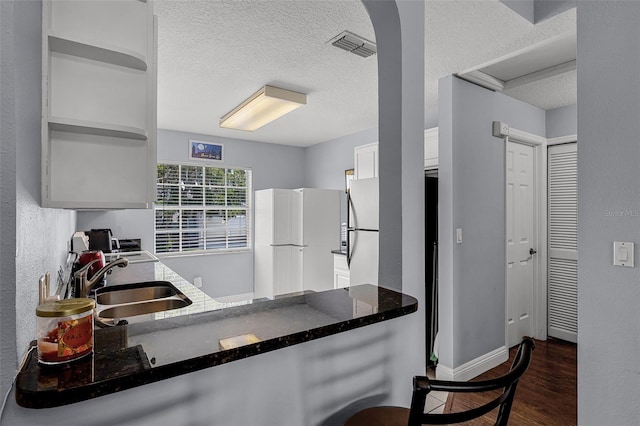 425 Eagle Ridge Dr Unit 425, Davenport, FL 33837 - kitchen featuring a sink, a textured ceiling, open shelves, dark wood-type flooring, and white cabinetry