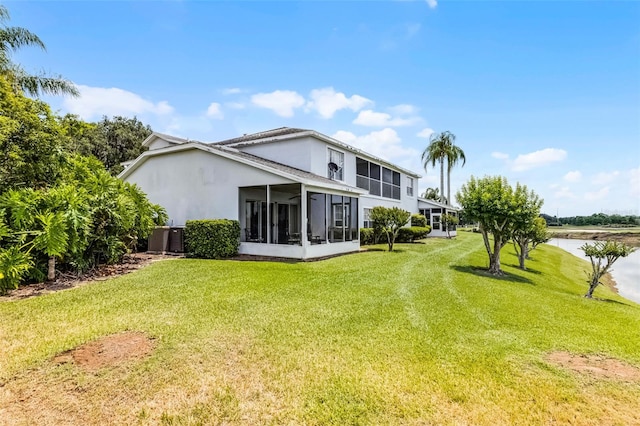 425 Eagle Ridge Dr Unit 425, Davenport, FL 33837 - rear view of house with a sunroom, stucco siding, a yard, a water view, and cooling unit