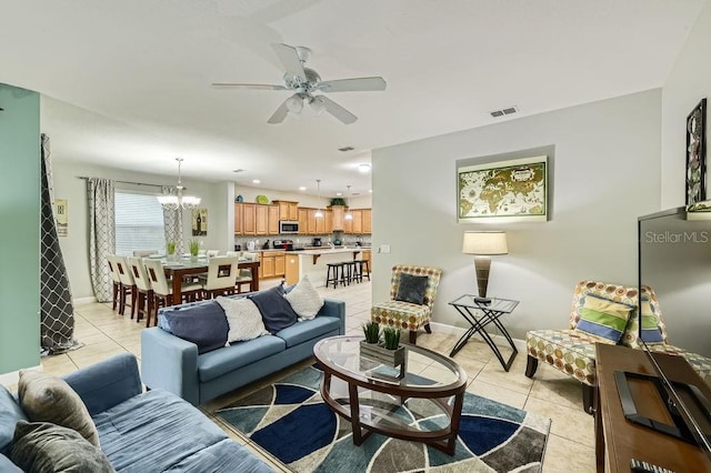 living area featuring light tile patterned flooring, a ceiling fan, a chandelier, and baseboards