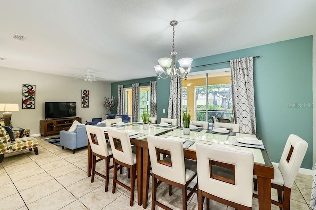 tiled dining space featuring a chandelier and a ceiling fan