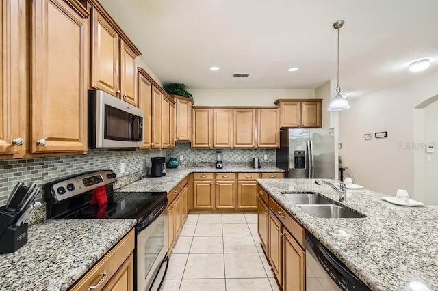 kitchen featuring stainless steel appliances, a sink, tasteful backsplash, light stone counters, and light tile patterned floors