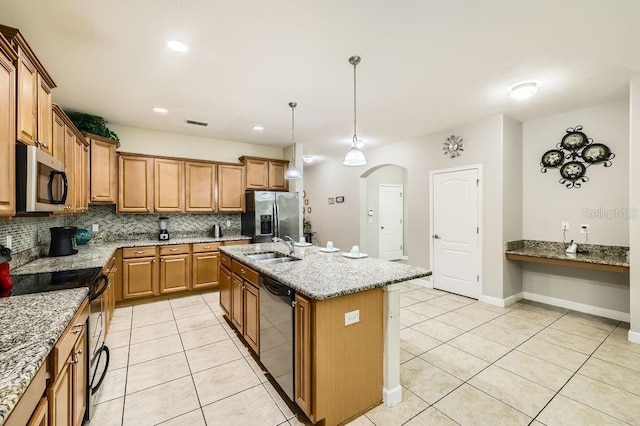 kitchen with stainless steel appliances, a sink, light tile patterned floors, arched walkways, and recessed lighting