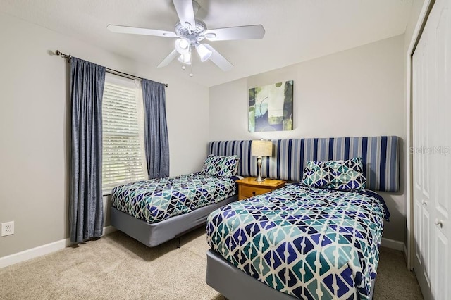 carpeted bedroom featuring a closet, baseboards, and a ceiling fan