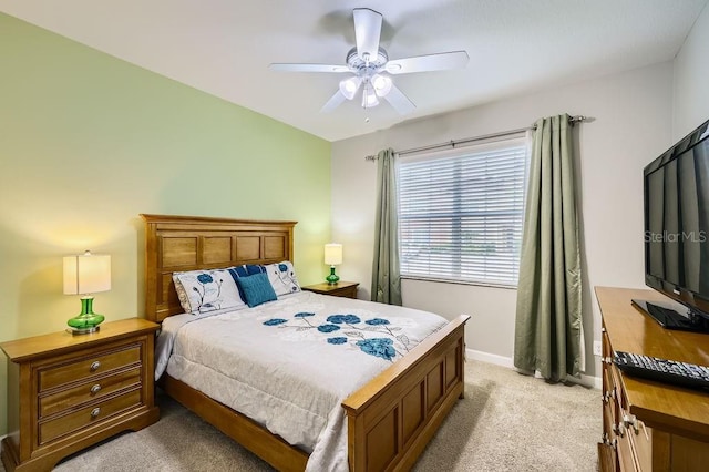 bedroom with light colored carpet, baseboards, and a ceiling fan