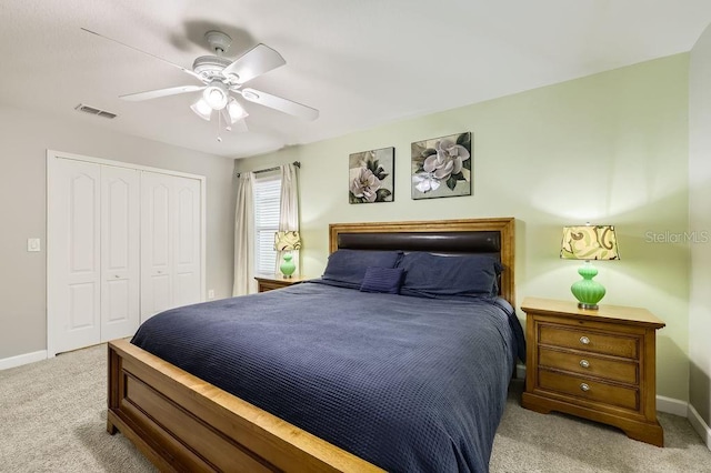 carpeted bedroom featuring a closet, baseboards, and a ceiling fan