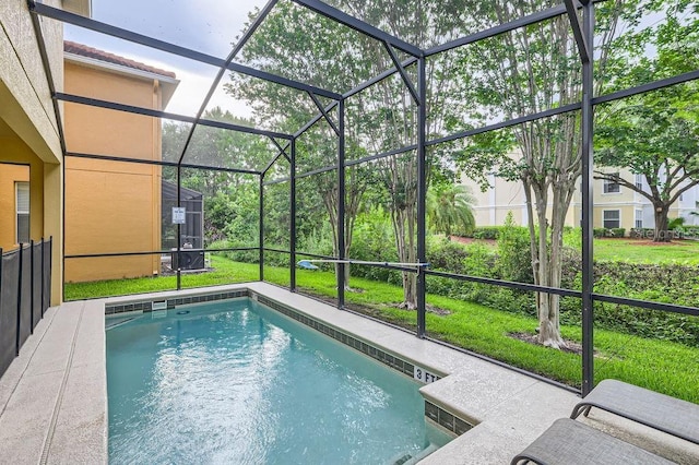 outdoor pool featuring glass enclosure and a lawn