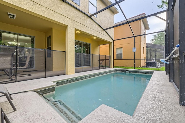 swimming pool with glass enclosure and a patio