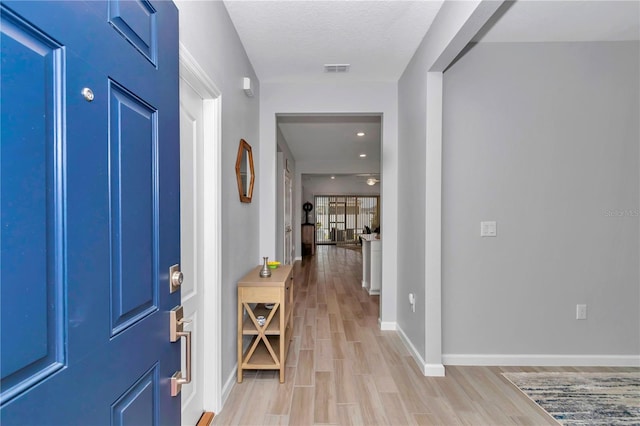 foyer with light wood finished floors and baseboards