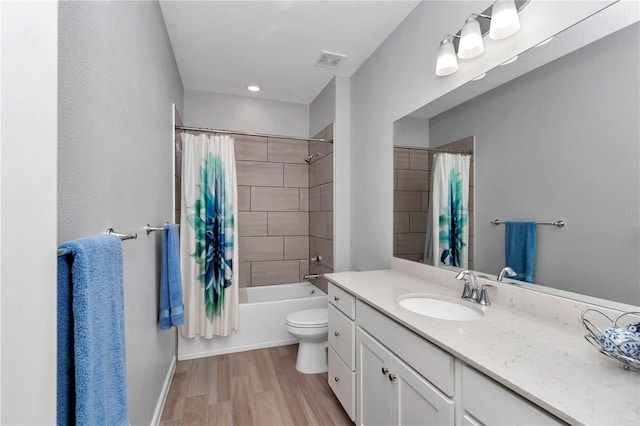 full bathroom featuring wood finished floors, vanity, toilet, shower / bath combo with shower curtain, and baseboards