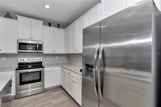 kitchen with stainless steel appliances, light countertops, white cabinetry, and recessed lighting