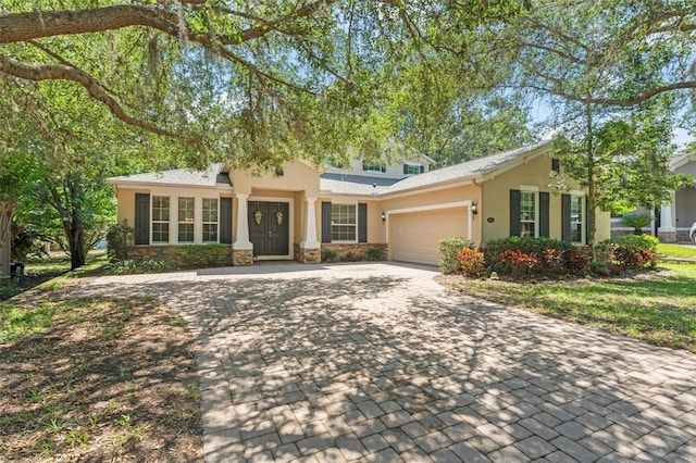 2827 Park Meadow Dr, Apopka, FL 32703 - view of front of home featuring stucco siding, an attached garage, decorative driveway, and stone siding