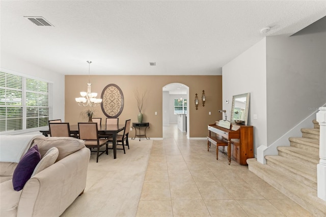 2827 Park Meadow Dr, Apopka, FL 32703 - living area with arched walkways, a chandelier, light tile patterned flooring, stairs, and a textured ceiling
