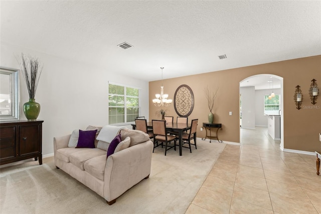 2827 Park Meadow Dr, Apopka, FL 32703 - living room with arched walkways, a chandelier, light tile patterned floors, and a textured ceiling
