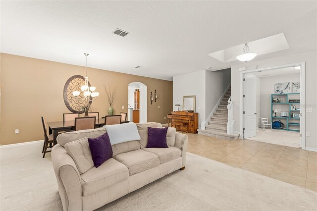 2827 Park Meadow Dr, Apopka, FL 32703 - living room with a chandelier, arched walkways, stairway, light carpet, and light tile patterned floors